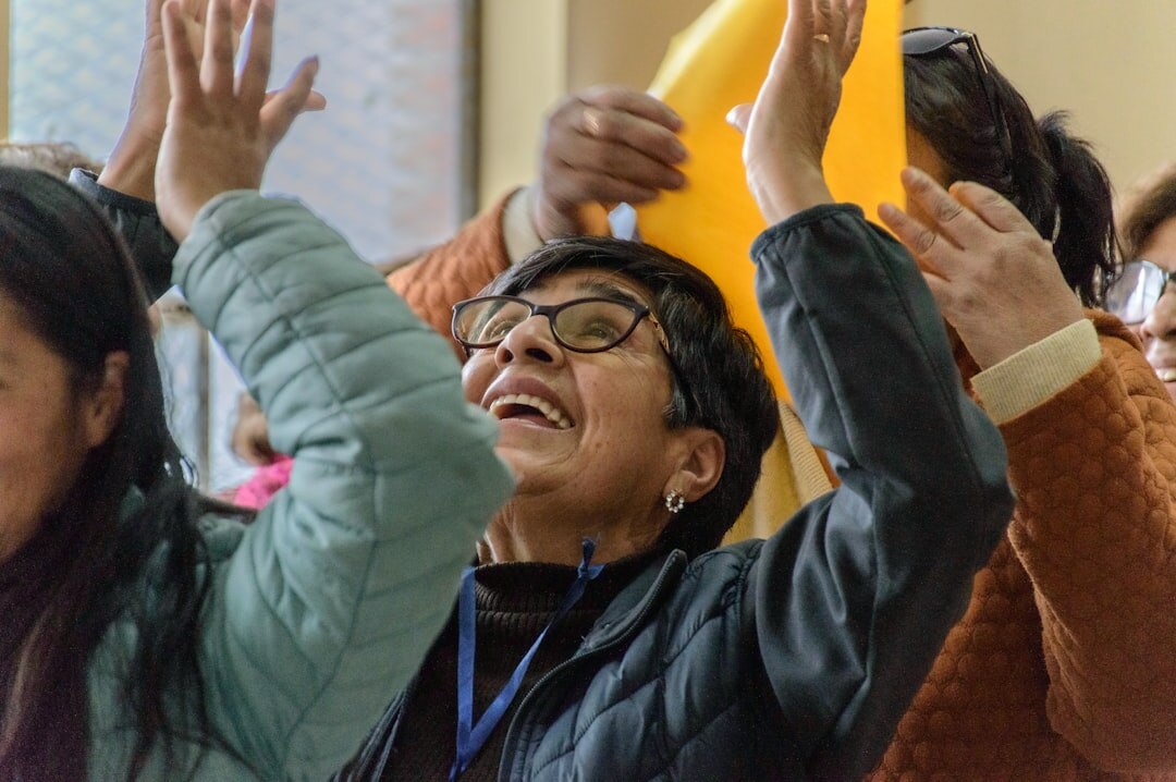 Group of happy seniors raising hands and celebrating together